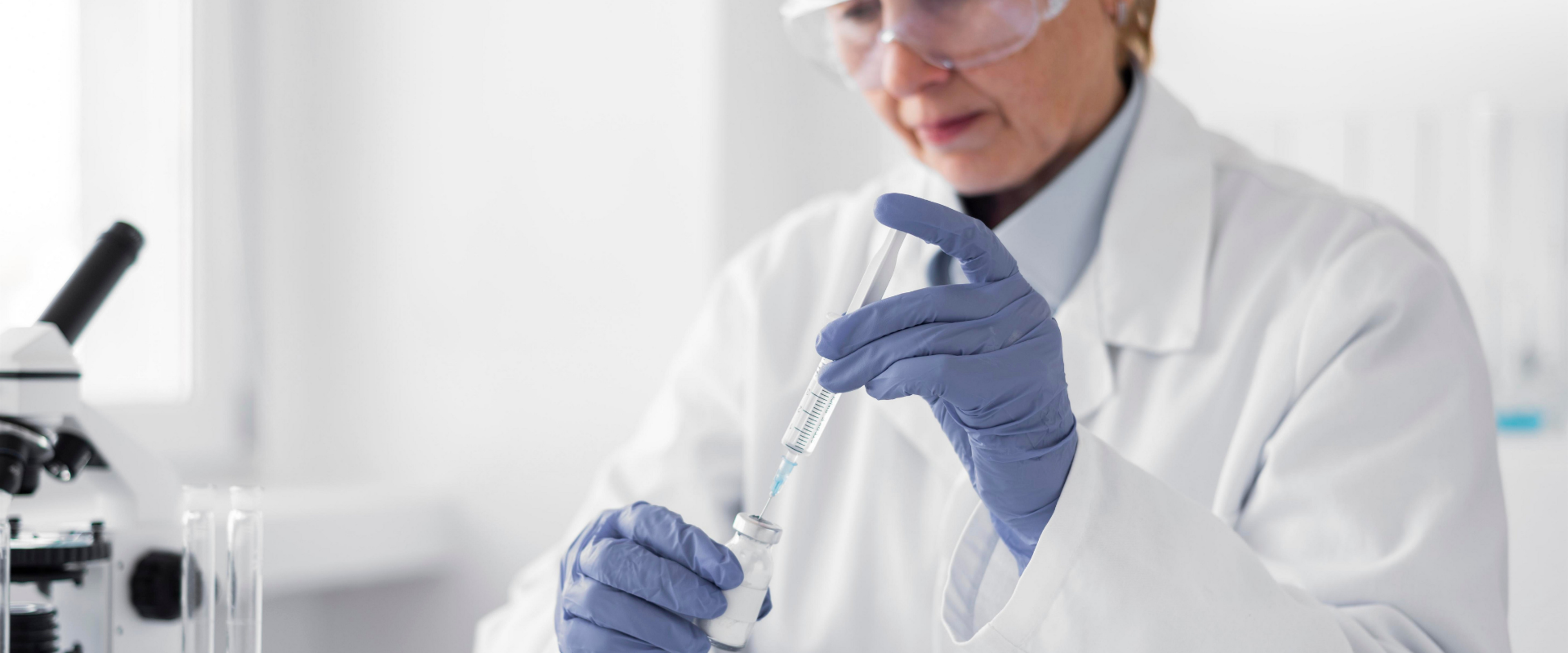 Nahaufnahme einer Person in Laborkleidung und blauen Handschuhen, die eine Spritze aufzieht, um eine medizinische Hautpflegelösung vorzubereiten, passend zum Thema dermatologische Systempflege.